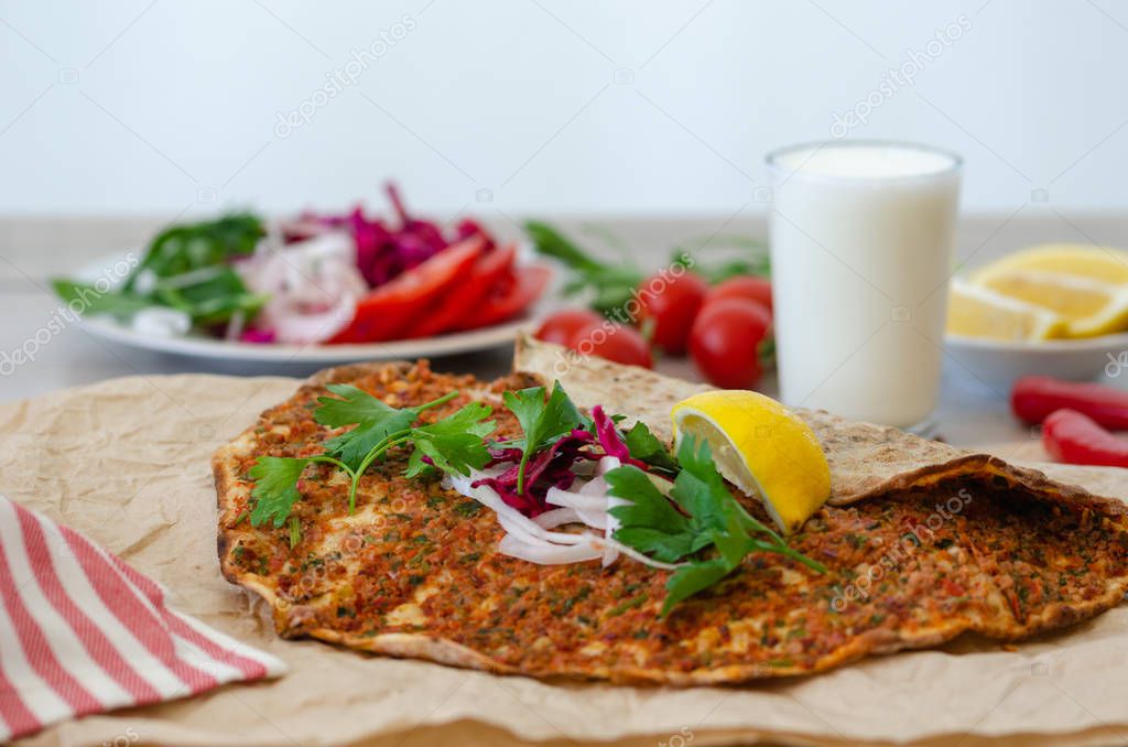 Turkish pizza with meat - lahmacun on a wooden table. Horizontal.