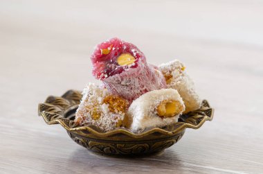 Türk lokumu geleneksel oyma desenli metal plaka, fıstık fındık ile yakın-up, izole.