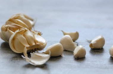  Soyulmuş sarımsak ampuller ahşap masa üzerinde. Seçici odak.