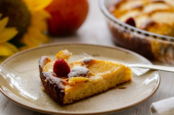 Pastadan ev yapımı şeftali bir plaka üzerinde. İşte bir ahududu ve toz şeker pasta seçici odak şeftali.