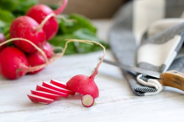 Dilimlenmiş turp ve bütün turp beyaz tahta masada vardır.