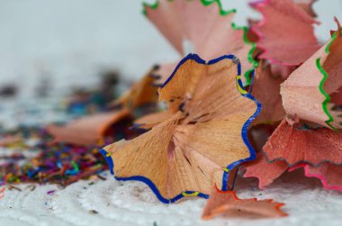 Beyaz masada renkli kalemler keskinleştirme talaşı yakın çekim