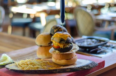 İştah açıcı ve lezzetli hamburger hazır servis gerekir. Arka plan bulanık,