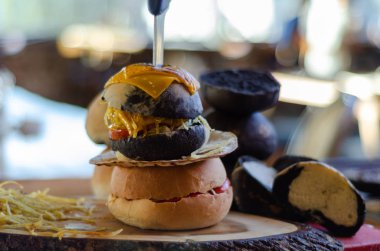 İştah açıcı ve lezzetli hamburger hazır servis gerekir. Arka plan bulanık, orada vardır hamburger yanındaki siyah ekmek