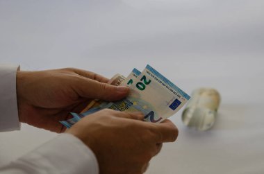 Adam beyaz zemin üzerine onun elinde euro tutuyor.