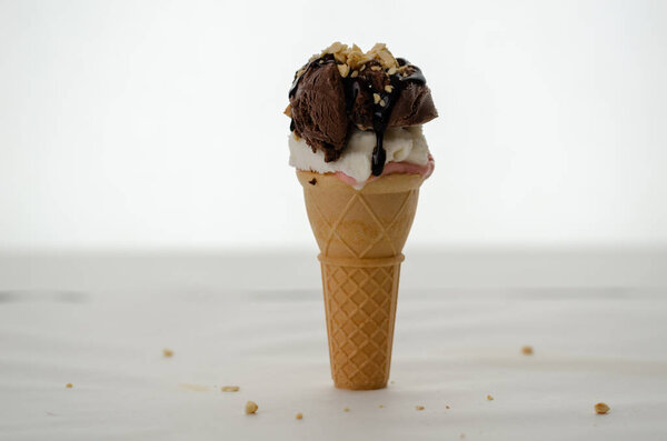 Шоколадный шарик мороженого и шоколадный соус на белом фоне
