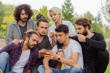 Bir grup genç insan Park cep telefonları ile çalışıyoruz