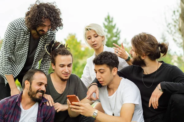 Gruppo Giovani Lavora Nel Parco Con Telefoni Cellulari — Foto Stock