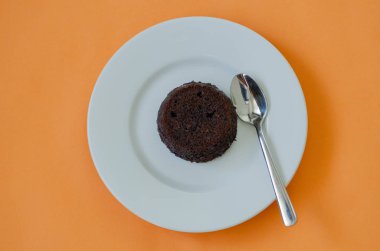 Sıcak çikolatalı kek sufle turuncu zemin üzerine.