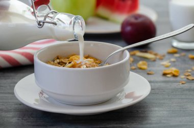 Granola tahıl gevreği kurutulmuş meyve, fındık ve bal beyaz bir kase ile.