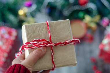 Kadın bir hediye paketi elinde tutuyor