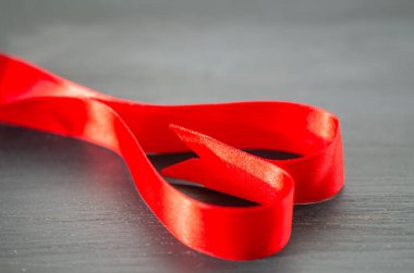 Siyah zemin üzerine kırmızı kurdele kalp şeklinde olduğunu.