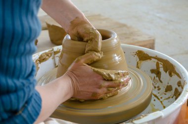 Yakın çekim yakışıklı kadın Potter Clay, seçici odak bir vazo yapma önlük