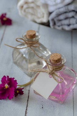 Havlu ve beyaz arka plan üzerinde üstten görünüm, izole şişeler güzel çiçeklerle yakın çekim