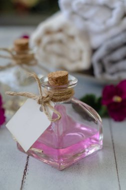 Havlu ve beyaz arka plan üzerinde üstten görünüm, izole şişeler güzel çiçeklerle yakın çekim