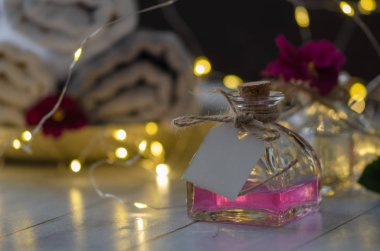 Rahatlatıcı spa set, ışıklar ve aromaterapi şişe üzerinde mavi arka plan, yakın çekim ,