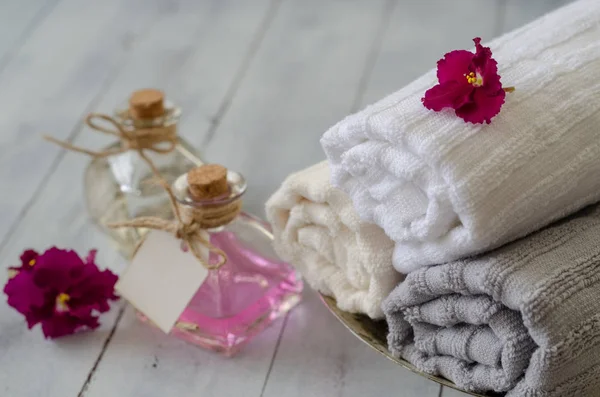 Havlu ve beyaz arka plan üzerinde üstten görünüm, izole şişeler güzel çiçeklerle yakın çekim