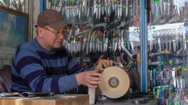 Eskişehir, Türkiye-Ocak 14,2016: Adam taşlama aşındırıcı kesim ve bıçak bileme taş Cutlers ın Bazaarı