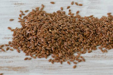 Keten tohumu ahşap arka plan üzerinde. Tahıl, izole beyaz ahşap zemin yığını. Tahıllar. Vitaminler. Sağlıklı gıda