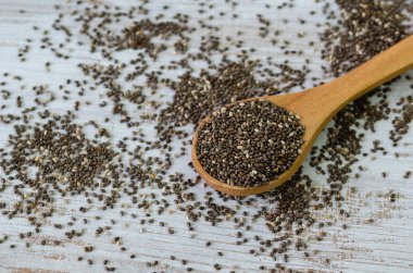 Tahta kaşık ile beyaz arka plan izole Chia tohum