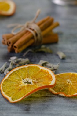 Kurutulmuş portakal dilimleri, adaçayı ve tarçın ahşap tablo.