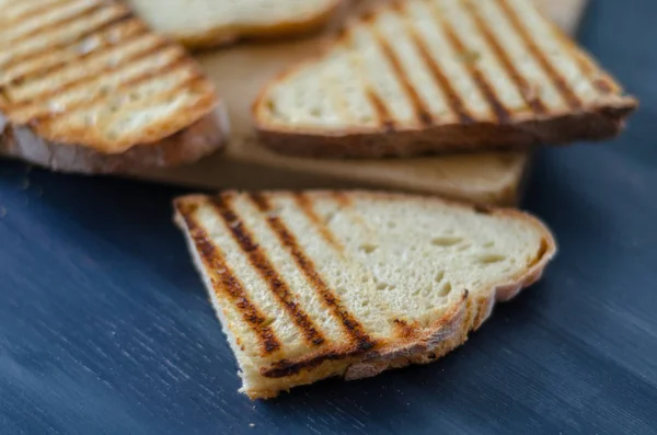 Slices of fresh toasted bread on wooden background