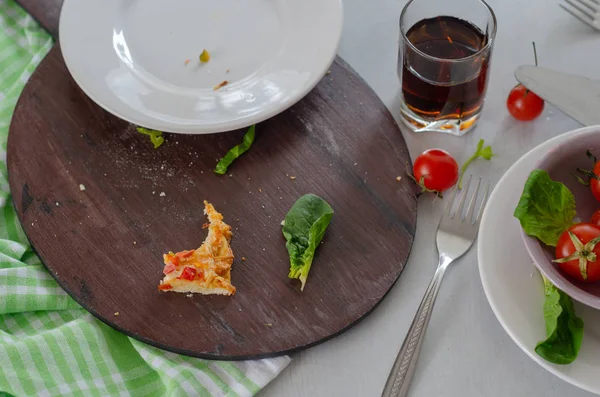 There are remains of pizza,beverage, cheery tomatoes and dirty p — Stock Photo, Image