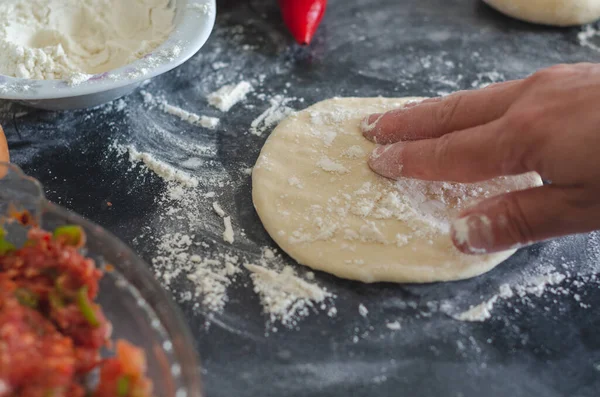 Kadın eli, un ve hamur. Bir kadın ev yapımı için hamur hazırlıyor. Hamuru ve masayı un yap. Ev yemeği konsepti, evde pişirme.