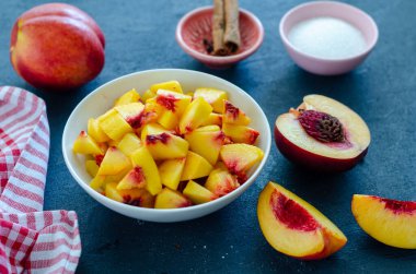 Doğranmış şeftali ve şeftali bir masada, yakın plan. Komposto veya reçel yapmaya hazır.