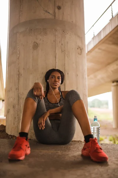 Young Black Woman Sportswear Sitting Ground Leaning Concrete Pillar Resting — Stock Photo, Image