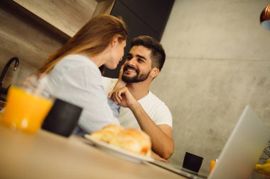 Genç çift birlikte sabah kahvesi ve kahvaltı keyfi portresi.