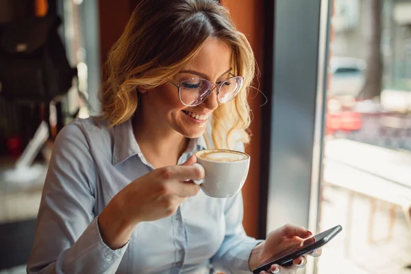 Młoda Kobieta Pomocą Jej Smartphone Kawiarni Podczas Przerwy Kawę — Zdjęcie stockowe