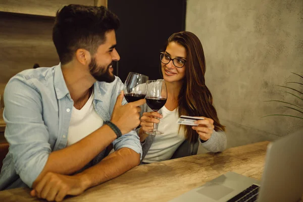 Pareja Joven Bebiendo Vino Mientras Está Sentada Cocina Haciendo Compras — Foto de Stock