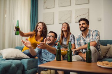 Grup Genç arkadaşlar eğlenmeye evde bira yudumlarken