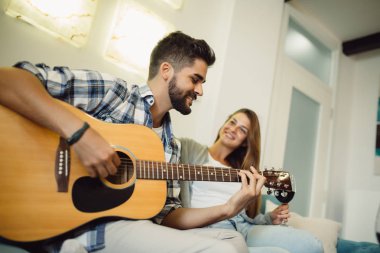 Erkek kız arkadaşıyla gitar çalmak ve kapalı zevk portresi