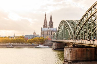 Parlak sonbahar güneşi altında muhteşem Köln Katedrali ve Hohenzollern Köprüsü
