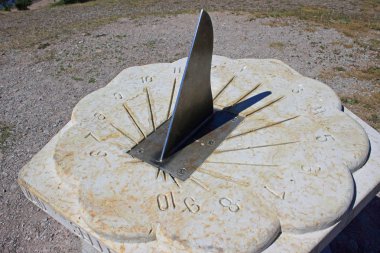 Dolomite sundial displays summer time, and it has compass rose on the ground. Photo taken on sunny summer day at 14.30  in Panga on Saaremaa island in Estonia. clipart