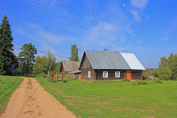 Obinitsa 爱沙尼亚 2018年9月10日 传统样式农舍与原木墙壁和白色窗口框架由村庄路在绿色草之后 背景中的树木和蓝天 — 图库照片