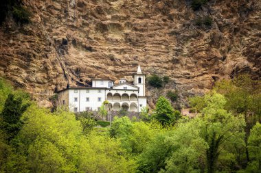 Calomini (Eremo di Calomini), muhteşem bir konuma yerleştirilen güzel Hermitage görünümü, dik kireçtaşı duvarın dibinde. Vergemoli, Lucca, Garfagnana, Toskana, İtalya),