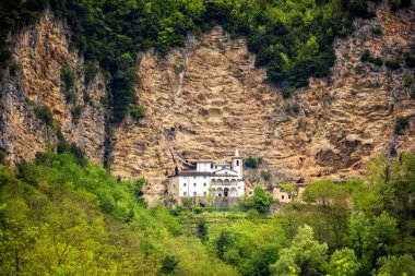 Calomini (Eremo di Calomini), muhteşem bir konuma yerleştirilen güzel Hermitage görünümü, dik kireçtaşı duvarın dibinde. Vergemoli, Lucca, Garfagnana, Toskana, İtalya