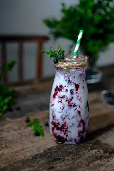 Purple milk smoothie with blueberries decorated with blueberries and leaves