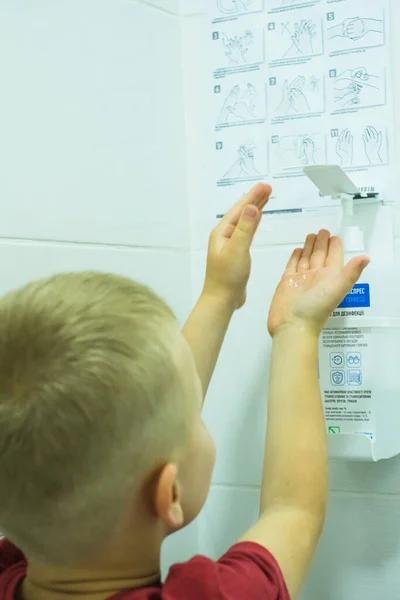 The child disinfects his hands in the toilet.Coronavirus. — Stock Photo, Image