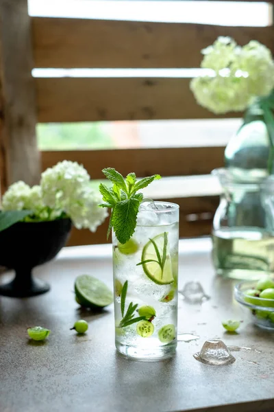 Segelas minuman musim panas yang menyegarkan dengan buah beri dan es batu di atas meja menutup — Stok Foto
