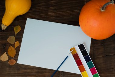 Sonbahar balkabağı, sarı yapraklar, boya, boş bir kağıt üzerinde fırça. Düz konum, üst görünüm, kopyalama alanı. Yüksek kalite fotoğraf