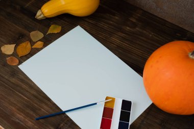 Sonbahar balkabağı, sarı yapraklar, boya, boş bir kağıt üzerinde fırça. Düz konum, üst görünüm, kopyalama alanı. Yüksek kalite fotoğraf