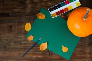 Sonbahar balkabağı, sarı yapraklar, boya, boş bir kağıt üzerinde fırça. Düz konum, üst görünüm, kopyalama alanı. Yüksek kalite fotoğraf