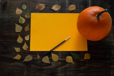 Kahverengi bir yaprağın üzerinde fırça, yapraklar, masanın üstünde balkabağı, üst manzara. Mesaj için yer. Cadılar Bayramı geçmişi. Yüksek kalite fotoğraf