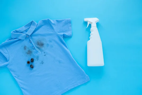 dirty black olive stains on clothes and stain removers. Stain cleaners.top view. Isolated on a blue background. High quality photo