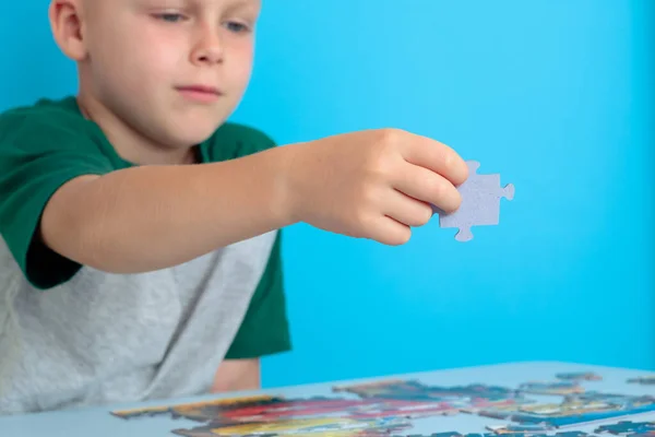 Närbild av en barnhand som håller i ett pussel. Tidigt lärande. — Stockfoto