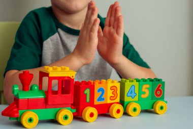  Trenle oynayan bir çocuk, rakamlar blokları. Anaokulu ve anaokulu çocukları için eğitici oyuncaklar. 